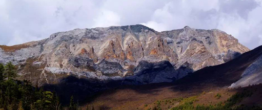 十六尊者：佛经中言，夏诺多吉神山的左侧泛绿之山为布鲁财神。神山的右下方为马头金刚，沿着马头金刚再往下就是特别明显的丹霞风林地貌。